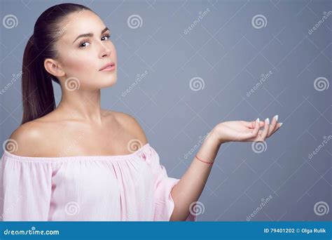 Portrait Of Beautiful Dark Haired Girl With Perfect Skin And Nude Make Up Showing Empty Palm