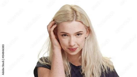 Shy Coy Blonde Caucasian Teenage Girl Standing Smiling On White Background In Slowmotion Stock