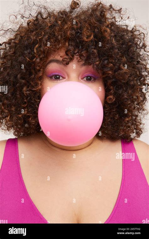 Brunette Woman Blowing Pink Balloon Stock Photo Alamy