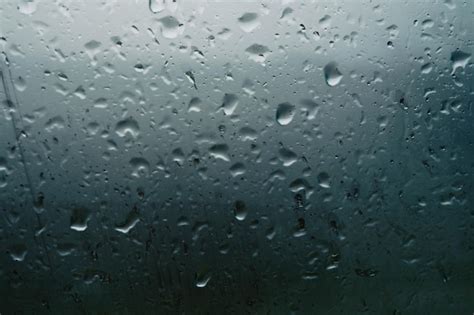 Gotas De Lluvia En Una Ventana Con Un Fondo Oscuro Foto Premium