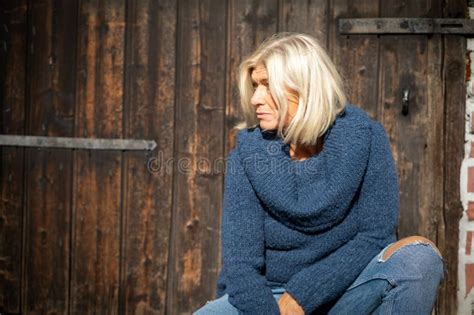 Blonde Woman In Her Mid Fifties Wearing A Wide Blue Knitted Sweater Stock Image Image Of