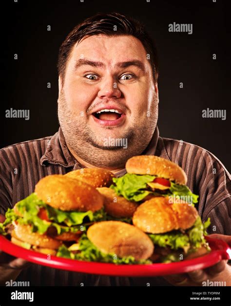 Hombre gordo comiendo hamburguesas fotografías e imágenes de alta