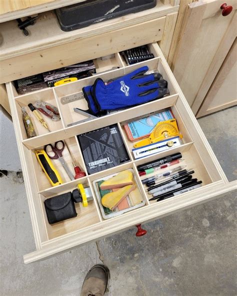 The Drawer Is Open And There Are Many Items In It Including Scissors