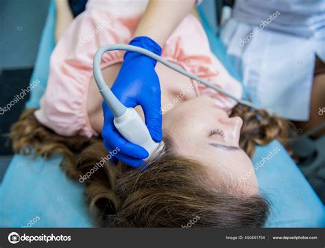 Doctor Using Ultrasound Scanning Machine For Examining A Head Of Woman