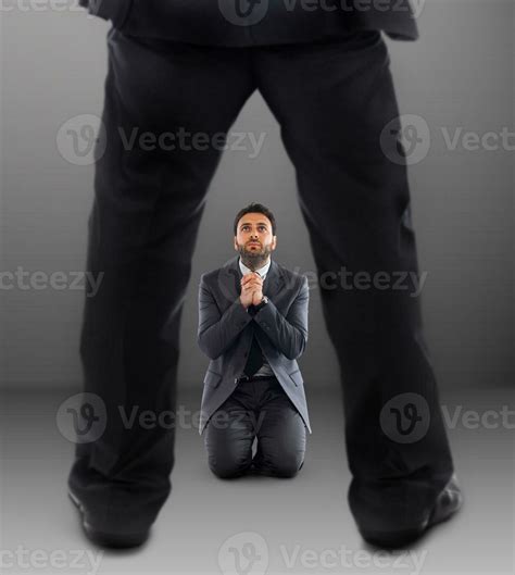 Business man on his knees praying not to be dismissed 24043468 Stock