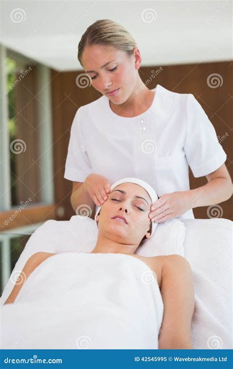Peaceful Brunette Getting Facial Massage From Beauty Therapist Stock