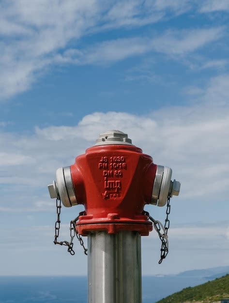 Premium Photo Ground Red Fire Hydrant Against A Cloudy Sky