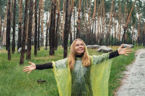 Happy Blonde Woman In Yellow Raincoat Enjoying Outdoors In Forest Rainy Weather Outside Leisure