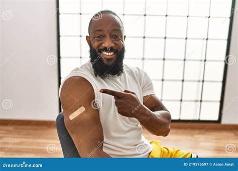 African American Man Getting Vaccine Showing Arm With Band Aid Smiling