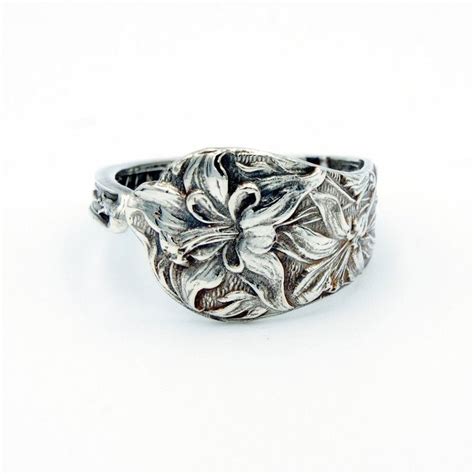 A Silver Ring With Leaves And Flowers On It