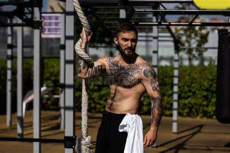 Muscular Bodybuilder Handsome Man With Naked Torso Trains Triceps In A Crossover Cable Exercise