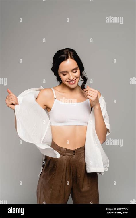 Smiling Brunette Woman In Top And Leather Pants Taking Off White Shirt