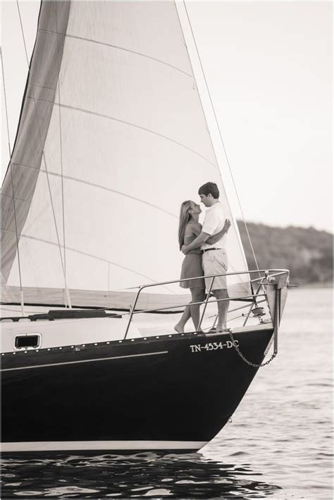 Two People Standing On The Side Of A Sailboat