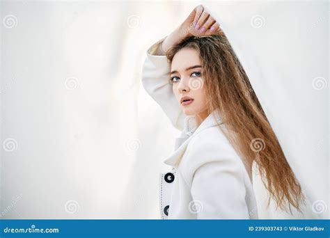 Young Attractive Woman In White Clothes Posing On Abstract Pale