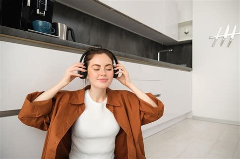 Free Photo Cute Brunette Woman On Kitchen Floor Wears Headphones