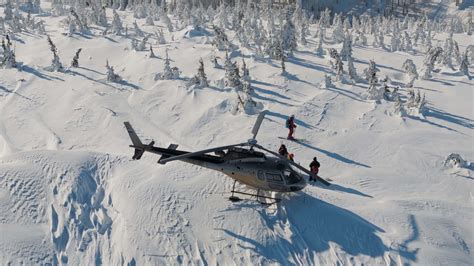 In snow helicopter aerial top view against forest mountains backdrop
