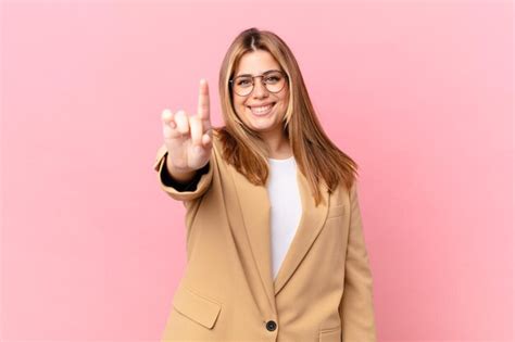 Premium Photo Curvy Pretty Blonde Woman Smiling And Looking Friendly Showing Number One