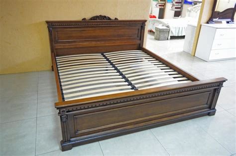 a wooden bed frame sitting on top of a tiled floor