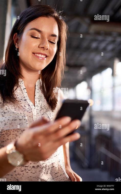 Friendly Brunette Backpacker Planning Her Trip And Consulting Her Mobile Phone In A Train