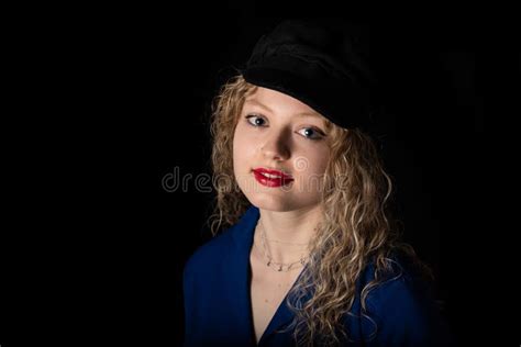 Studio Portrait Of A 21 Year Old White Blonde Woman With Curling Hair Wearing A Hat Stock Image