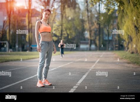 Attractive Brunette Woman Warm Up And Stretching In Park At Sunshine Stock Photo Alamy