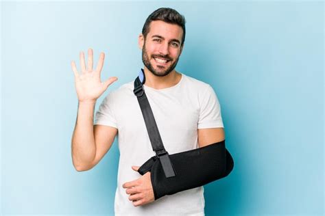 Premium Photo Young Caucasian Man With Broken Hand Isolated On Blue