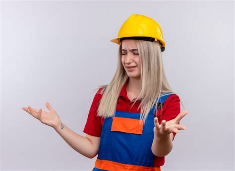 Agacé jeune fille blonde ingénieur constructeur en uniforme dans un appareil dentaire montrant