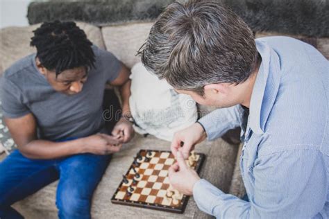 Un Par Gay Que Disfruta De Tiempo Dentro En Casa Jugando A Ajedrez Imagen De Archivo Imagen