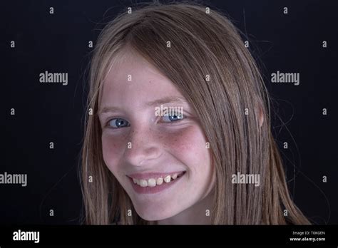 Belle jeune fille blonde avec des taches de rousseur à l intérieur sur un fond noir portrait