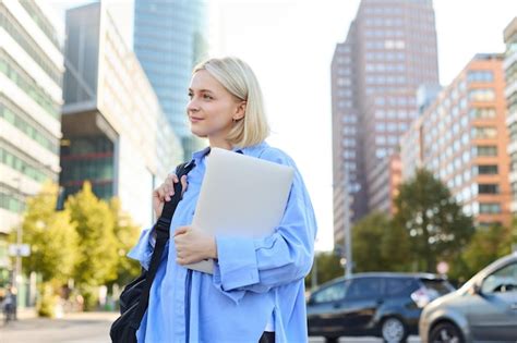 Portrait élégant de rue d une jeune femme blonde heureuse avec un sac à dos et un ordinateur