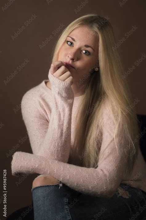 Nachdenkliche Blonde Frau Im Portrait Auf Braunem Hintergrund Stock Photo Adobe Stock