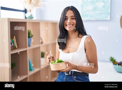 Brunette Woman Eating A Salad At Home Smiling With A Happy And Cool Smile On Face Showing Teeth
