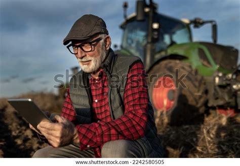 Mature Farmer Squatting Front Tractor Field Stock Photo Shutterstock
