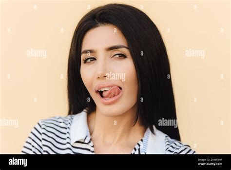 Close Up Portrait Of Beautiful Brunette Female Licks Lips With Tongue Looks Mysteriously Aside