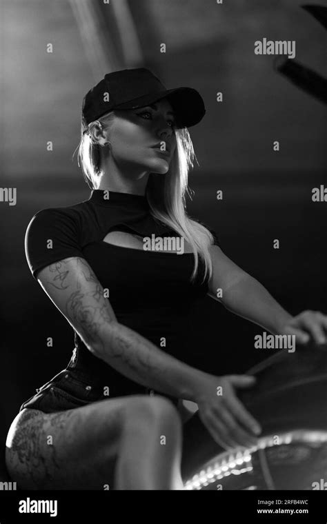 Beautiful Blonde Girl Posing While Sitting On Motorcycle In The Parking