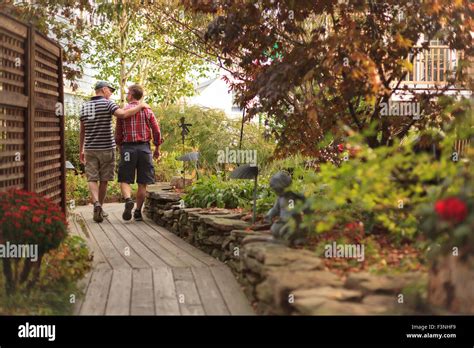 Gay Couple Age 40s Walking Through A Garden Stock Photo Alamy
