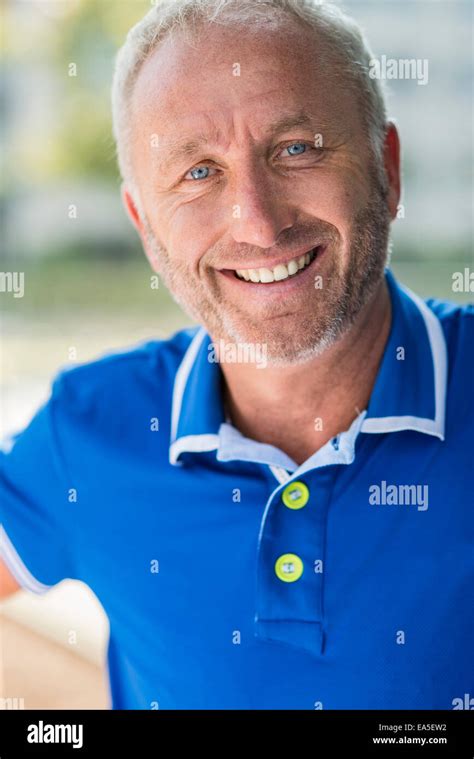 Portrait Of Smiling Mature Man Wearing Blue Shirt Stock Photo Alamy