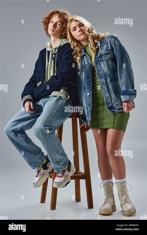 Blonde Teenage Girl Leaning On Redhead Boyfriend Sitting On High Stool