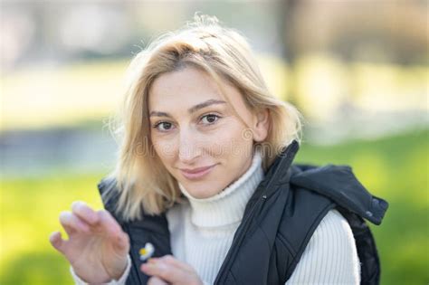 Blonde Woman Holding A Daisy In A Park Smiling Stock Photo Image Of Smiling Happy