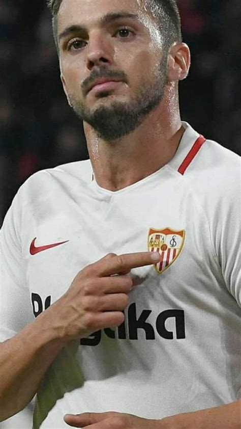 A Man With A Goatee On His Head Standing In Front Of A Soccer Field