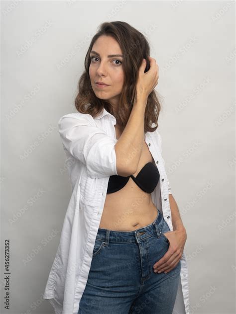 Model Brunette Posing On A White Background In The Studio She Is Wearing A White Shirt A