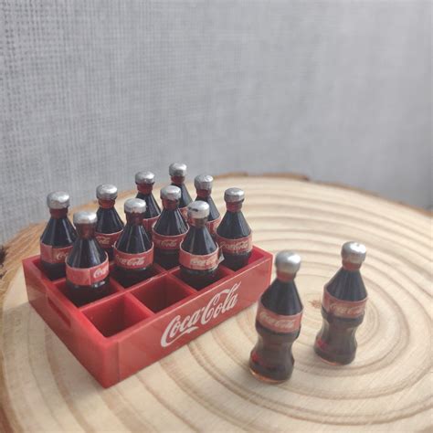 Se produkter som liknar Miniatyr Coca cola Ca 40mm Do på Tradera