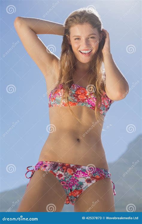 Bionda Sorridente In Bikini Floreale Sulla Spiaggia Immagine Stock