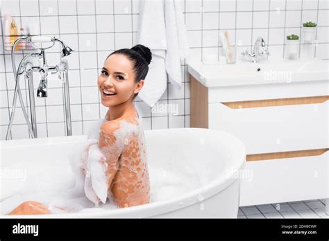 Brunette Woman In Foam Smiling At Camera While Taking Bath At Home Stock Photo Alamy