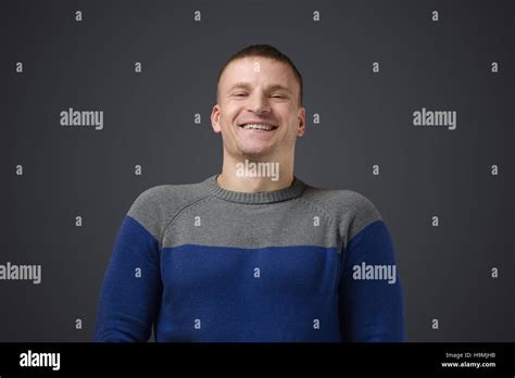 Portrait d un jeune gay men qui sourit Photo émotionnelle en studio sur un fond noir Photo