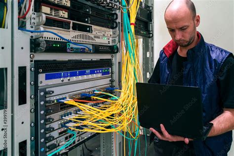 The System Administrator With A Laptop Is In The Server Room A Man