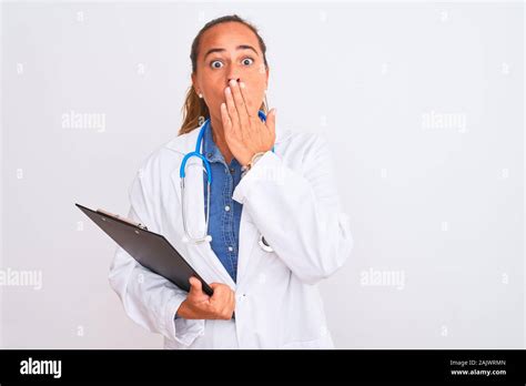 Middle Age Mature Doctor Woman Holding Clipboard Over Isolated Background Cover Mouth With Hand