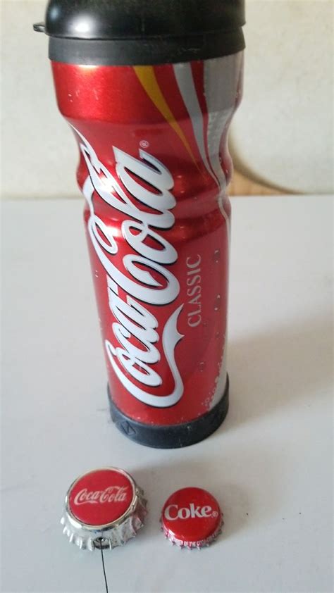 A Can Of Coca Cola Next To Two Small Round Chocolate Candies