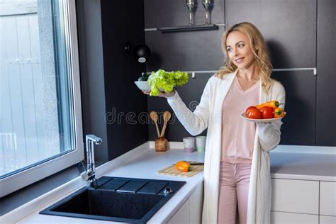 Una Feliz Y Sonriente Ama De Casa Parada En La Cocina Imagen De Archivo