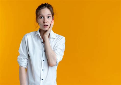 Jeune Fille Russe Blonde Choquée Met La Main Sur Le Visage Isolé Sur L espace Orange Avec Copie